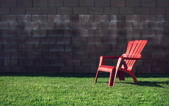 chaise de jardin en pvc de couleur rouge dans l'herbe